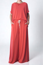 Pantaloni corai lejeri, largi și vaporoși, cu șnur alb în talie și buzunare laterale