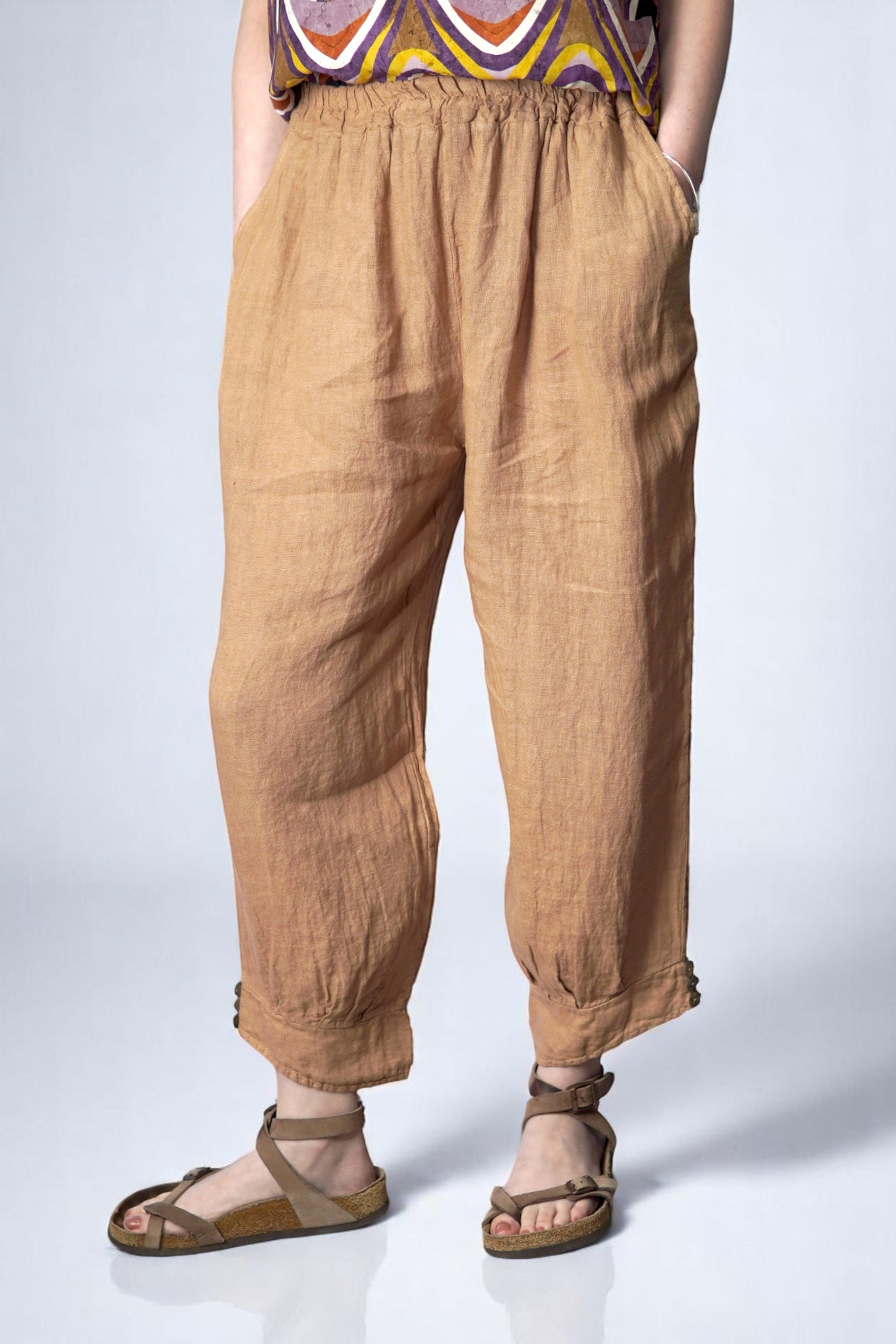 Pantaloni casual din in maro, cu buzunare laterale și tiv lat, pozați frontal complet.