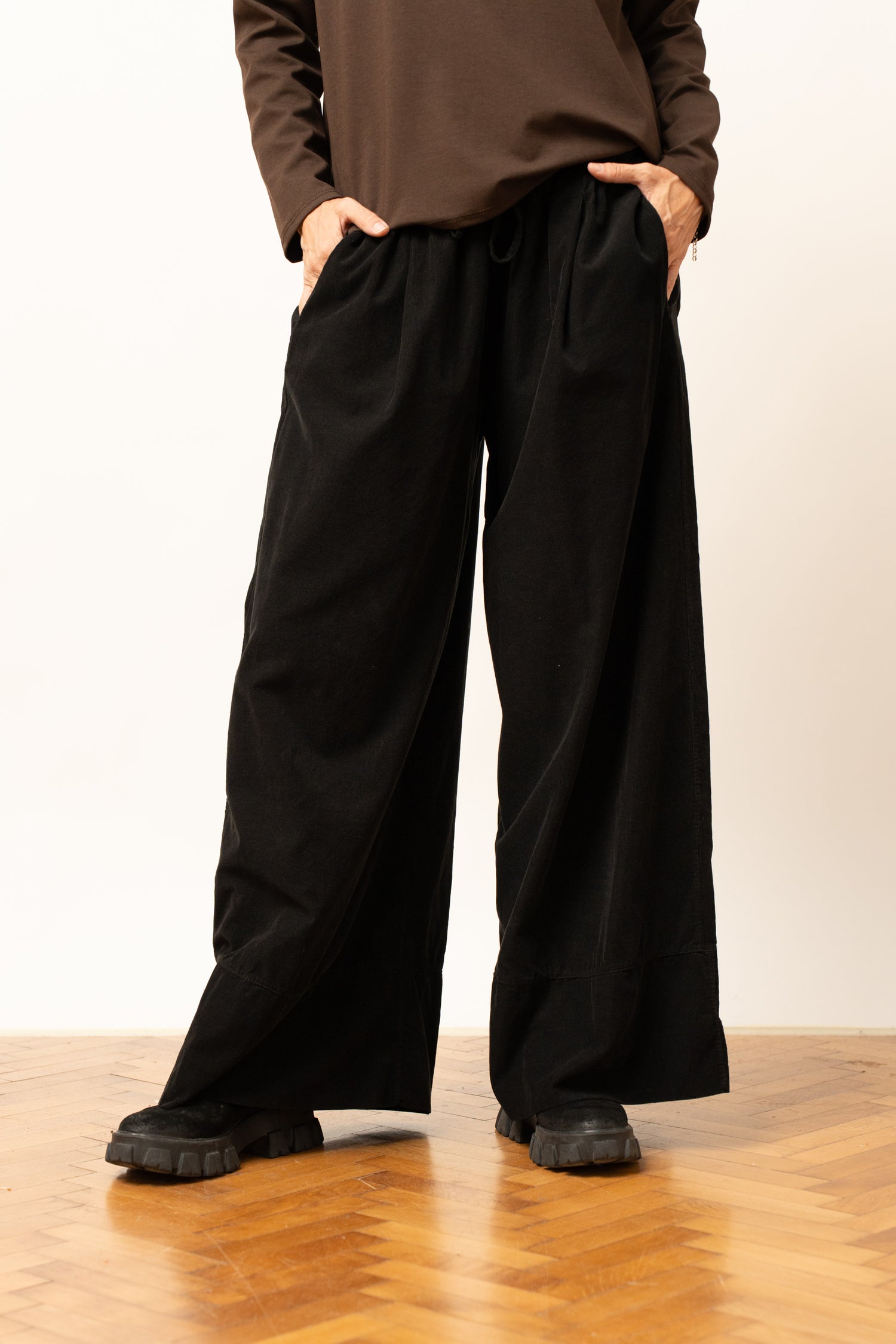 Pantaloni largi negri cu talie elastică și șnur reglabil, croială relaxată, vedere frontală.