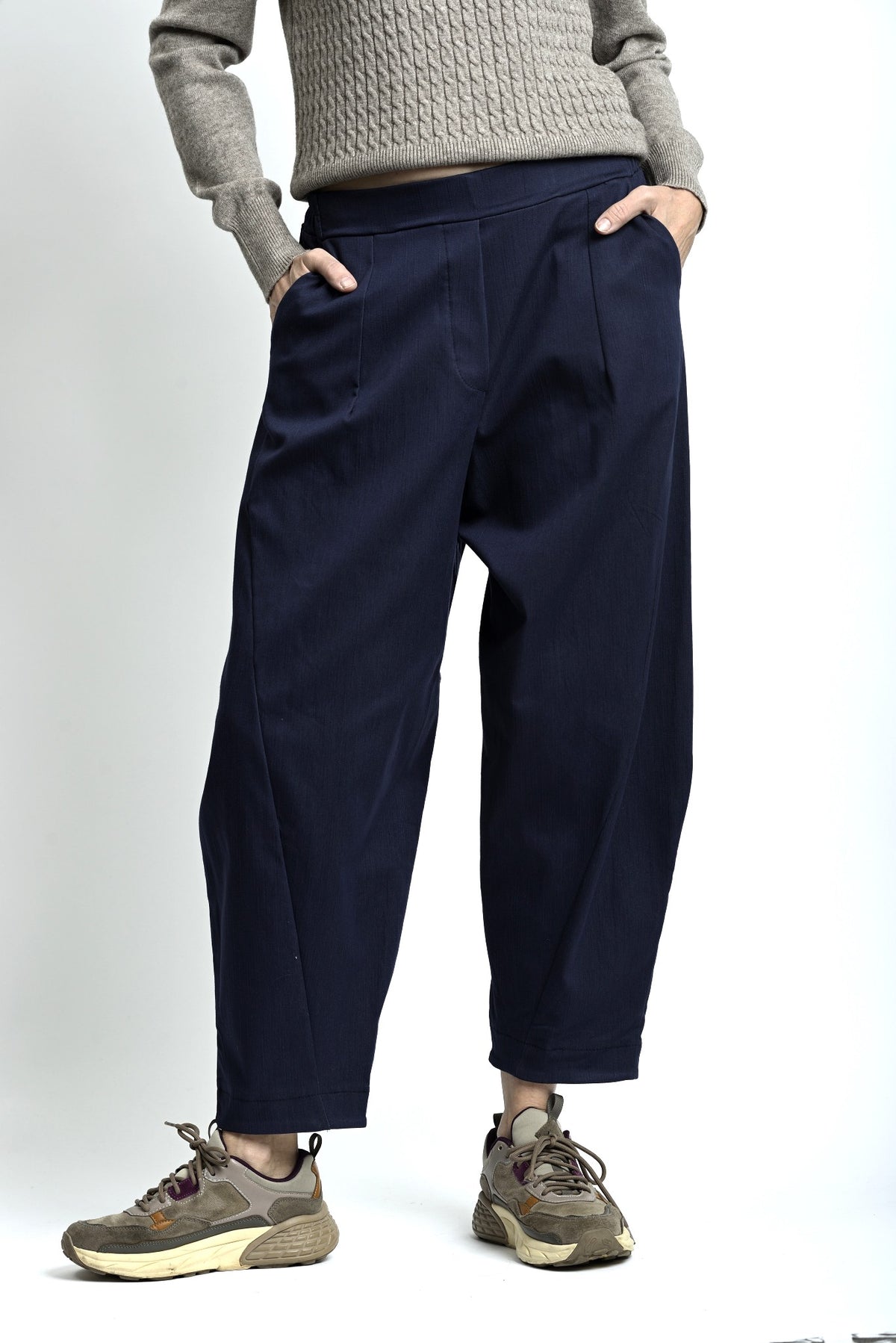 Pantaloni lejeri cu croială relaxată, culoare bleumarin, purtați cu top deschis și pantofi casual.