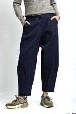 Pantaloni lejeri cu croială relaxată, culoare bleumarin, purtați cu top deschis și pantofi casual.