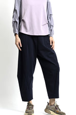 Pantaloni lejeri cu croială relaxată, culoare bleumarin, purtați cu top deschis și pantofi casual.