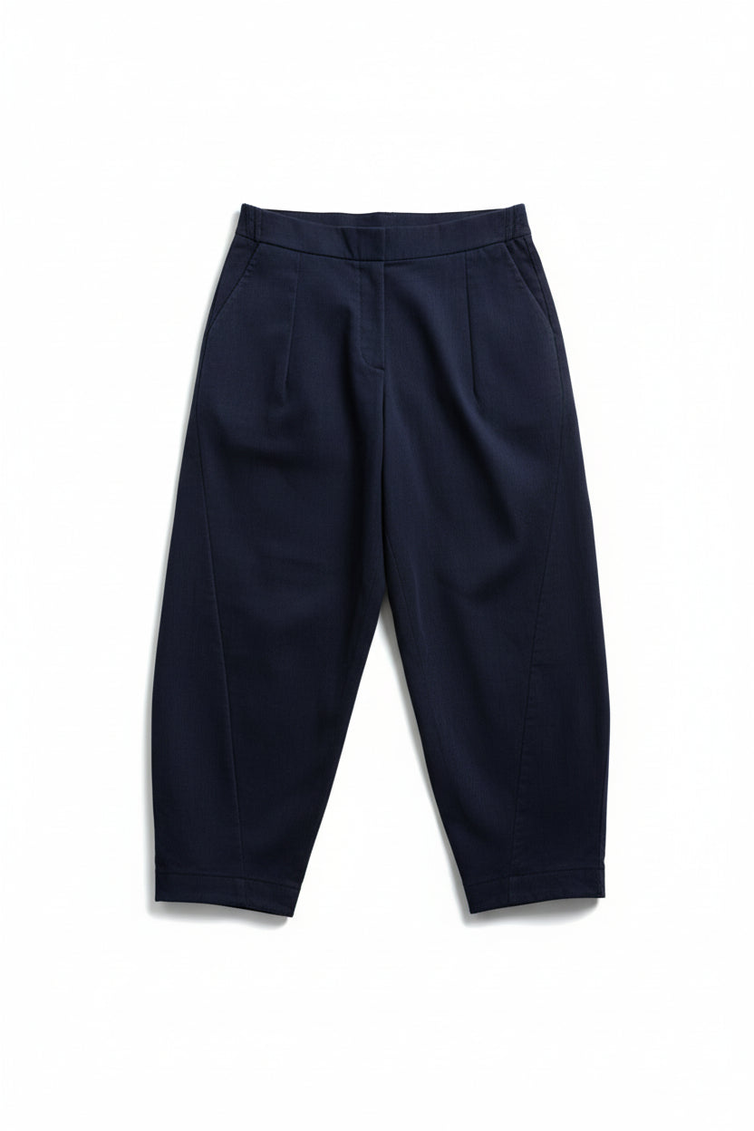 Pantaloni lejeri cu croială relaxată, culoare bleumarin, purtați cu top deschis și pantofi casual.