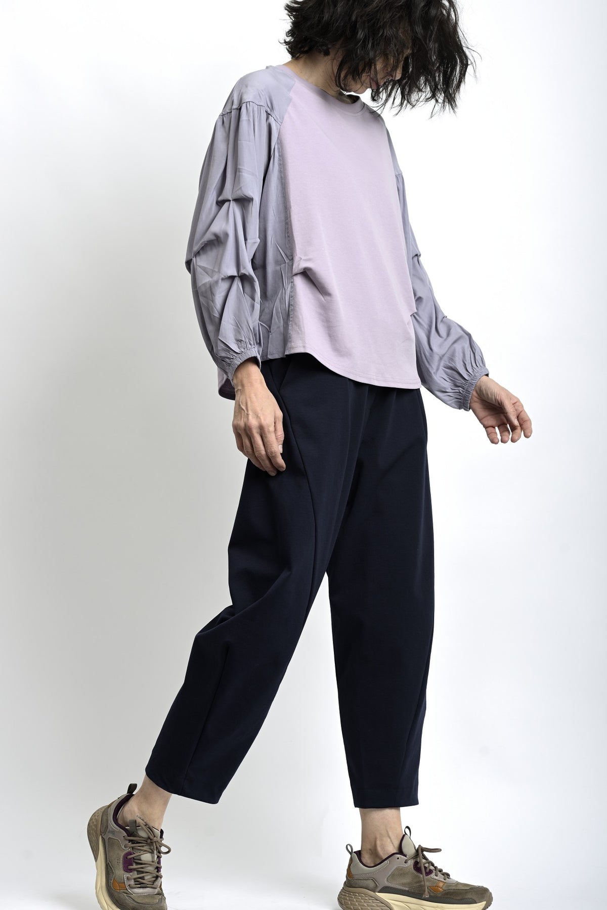 Vedere laterală a pantalonilor lejeri, evidențiind forma amplă și lungimea până la gleznă.