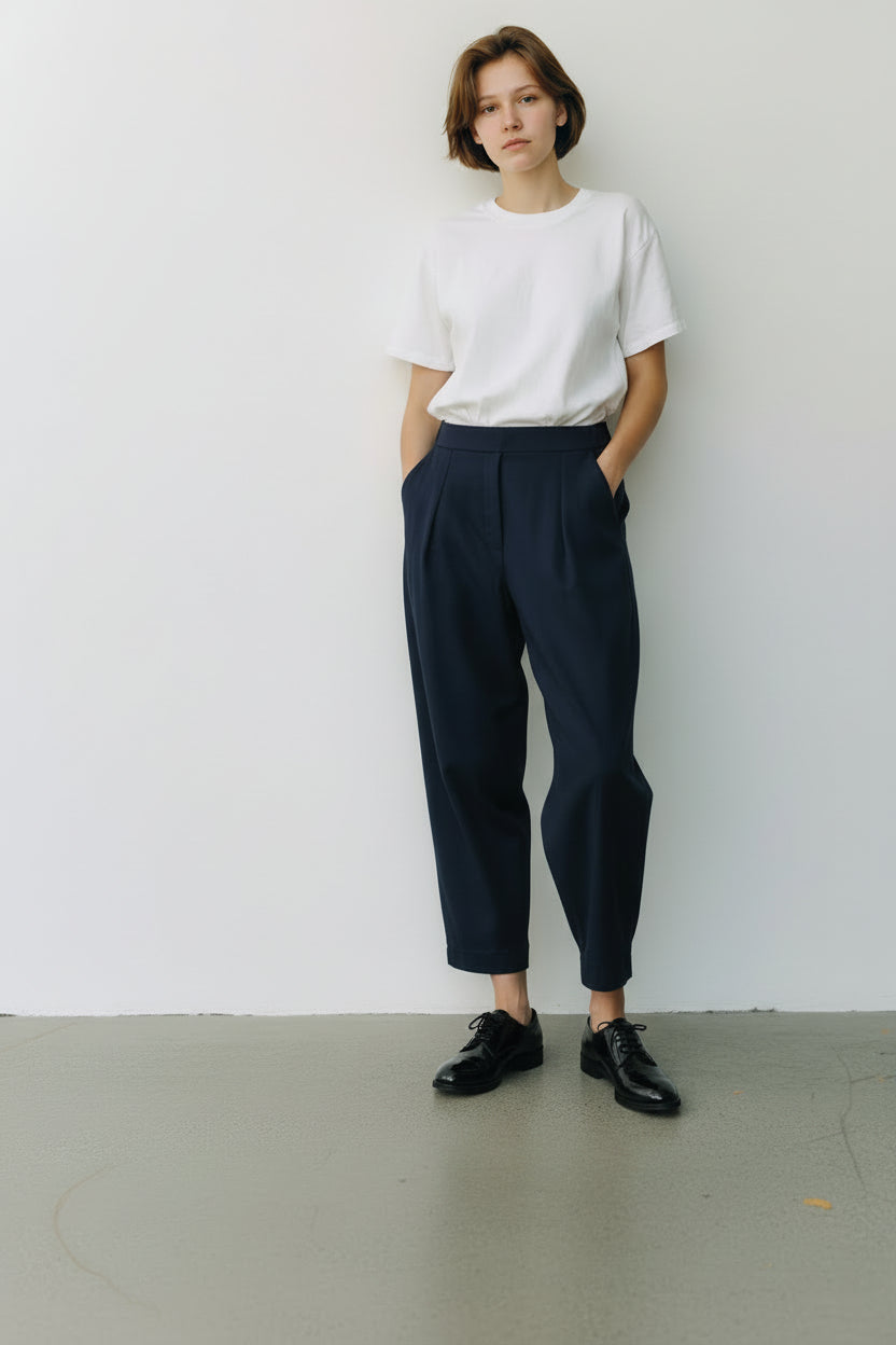 Pantaloni lejeri cu croială relaxată, culoare bleumarin, purtați cu top deschis și pantofi casual.