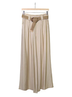 Pantaloni de damă bej, lungi și largi, cu pliuri și curea decorativă, confecționați din viscoză.