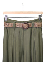 Detaliu curea împletită maro pe pantaloni verzi din viscoză, cu pense fine și talie elastică.