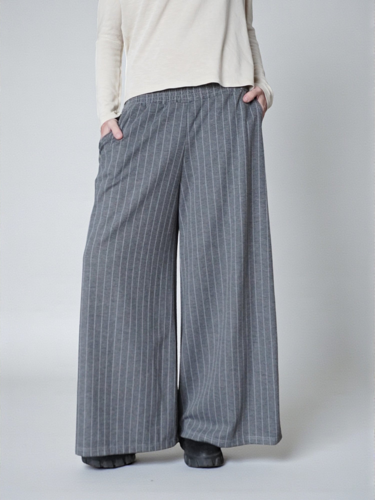 Pantaloni palazzo gri cu dungi fine verticale, croială amplă și talie elastică, vedere frontală.