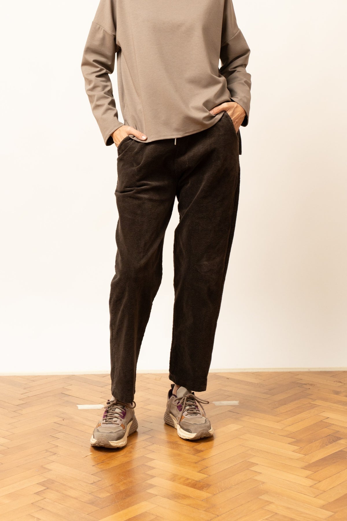 Pantaloni din reiat maro, croială lejeră și talie elastică cu șnur, vedere frontală.