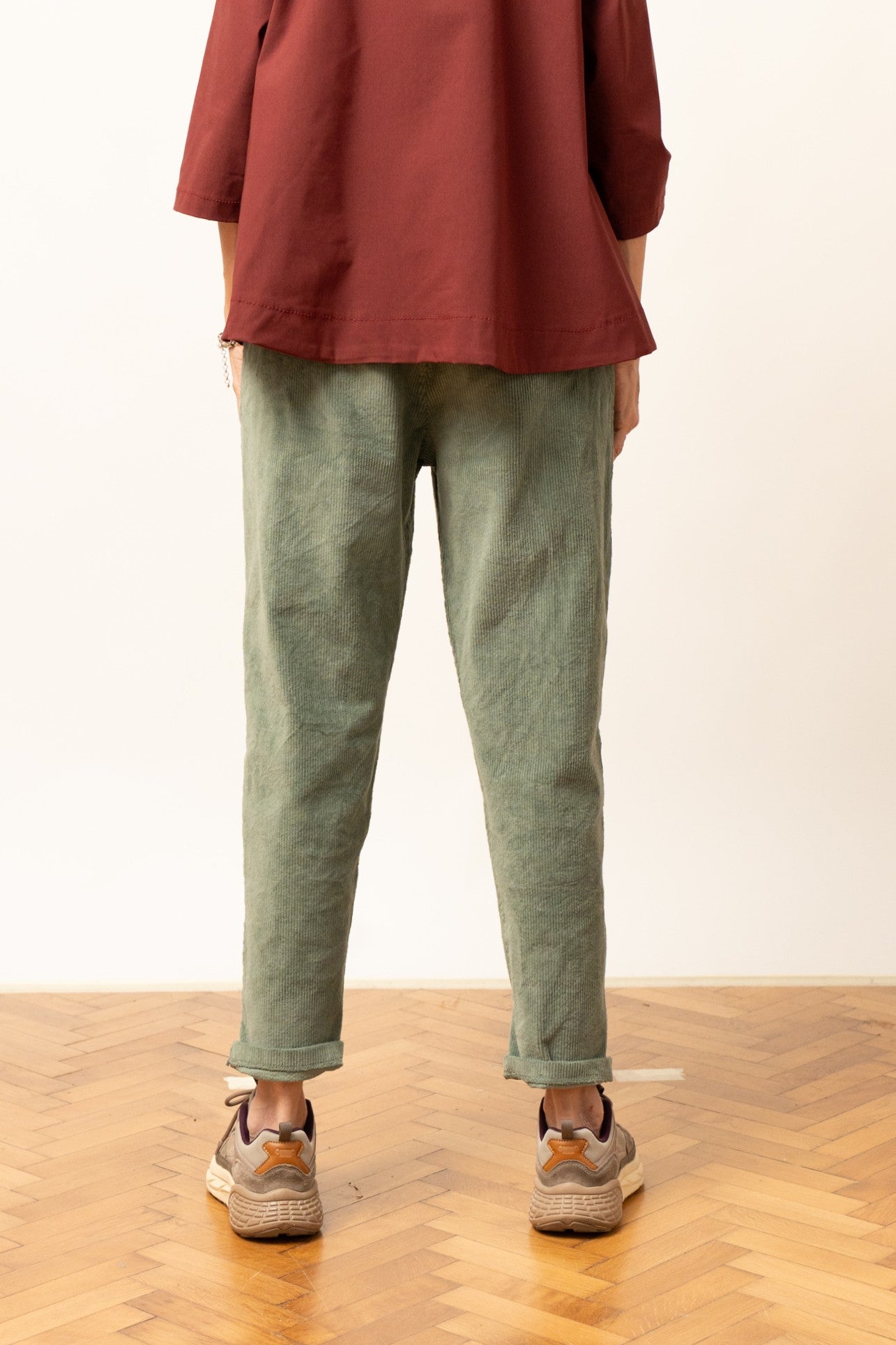 Pantaloni din reiat verzi, cu croială lejeră și tiv rulat, vedere din spate.