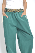 Detaliu talie cu elastic și curea etnică pe pantaloni verzi reiati din bumbac