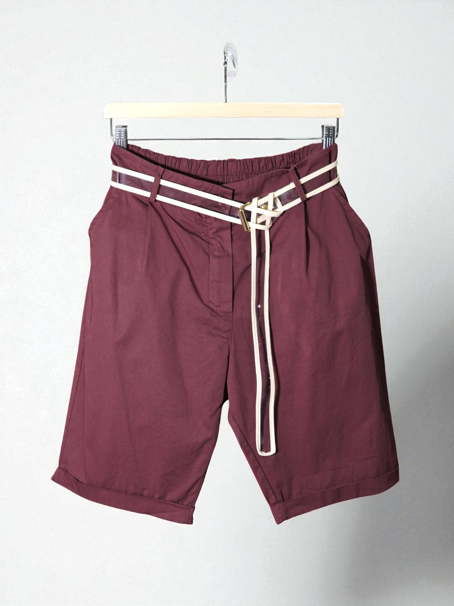 Pantaloni scurți visiniu cu croială lejeră, talie elastică și curea bej decorativă cu cataramă aurie.