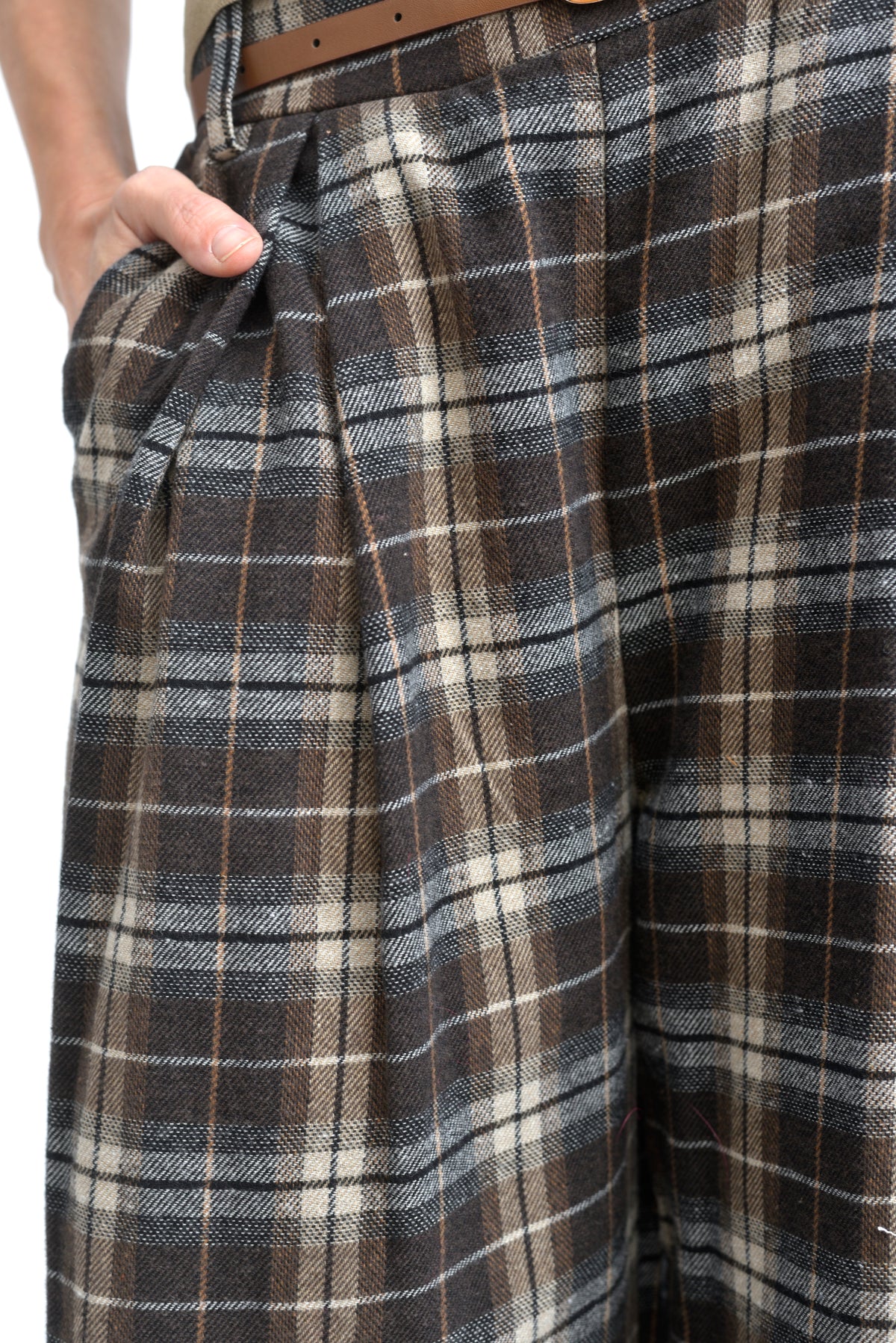 Detaliu de talie la pantaloni în carouri, cu curea maro și betelie ușor elastică.