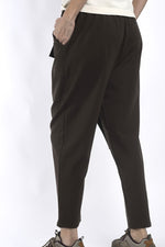 Vedere laterală a pantalonilor maro cu talie elastică și buzunar aplicat, aspect relaxat și confortabil.