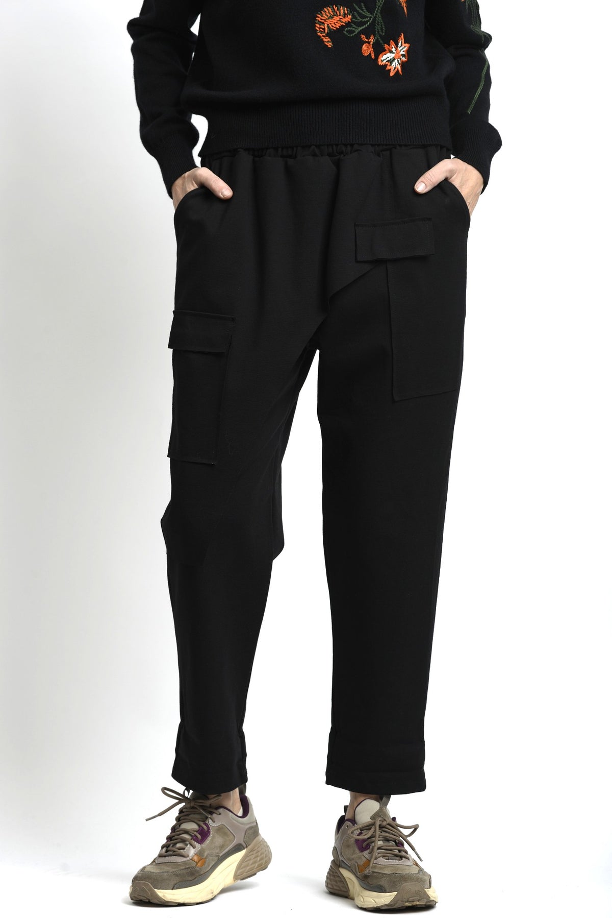 Pantaloni negru cu talie elastică și croială lejeră, purtați cu tricou deschis la culoare, vedere frontală.