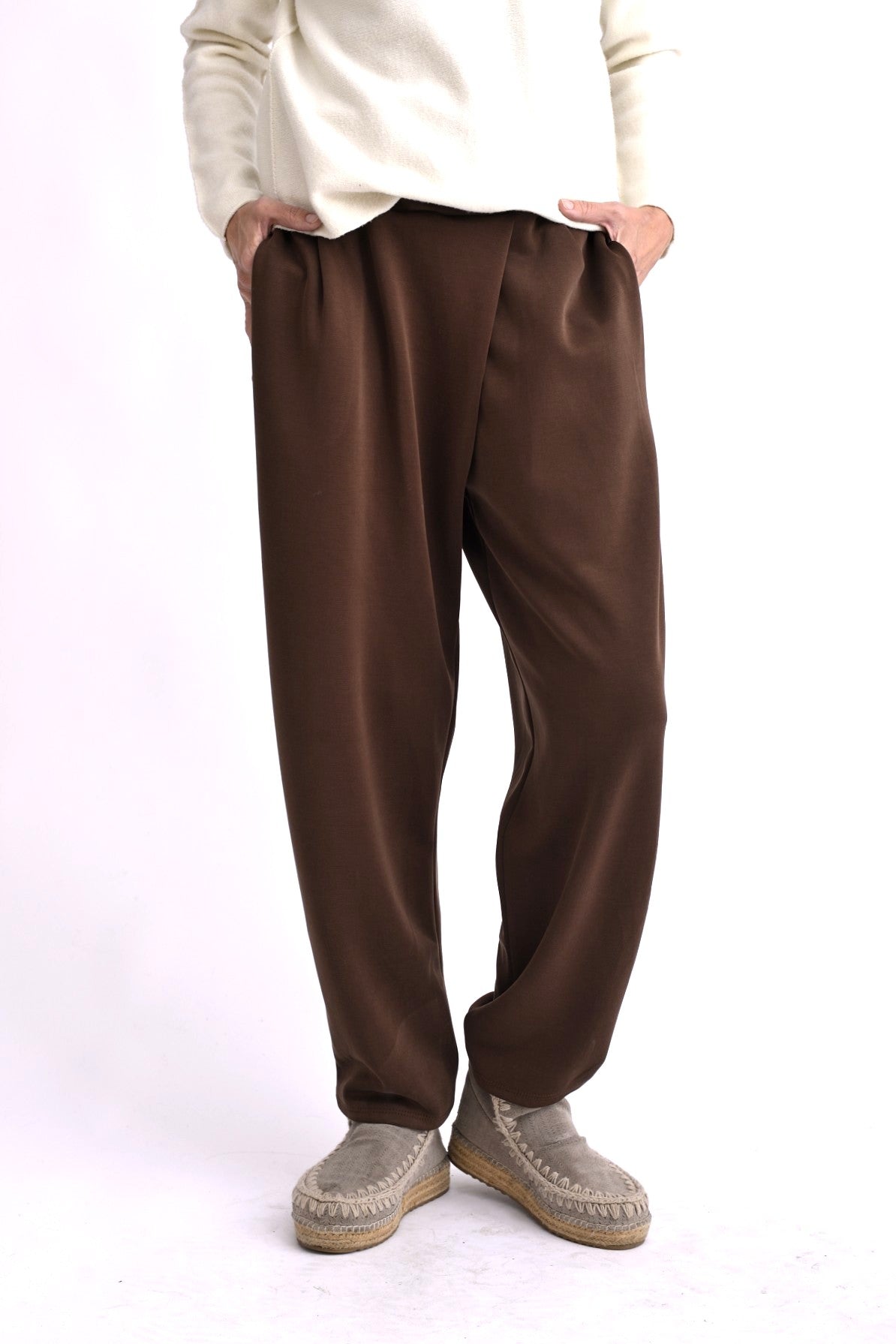 Pantaloni conici maro, tip trening elegant, cu pliuri frontale și talie elastică, purtați pe model.