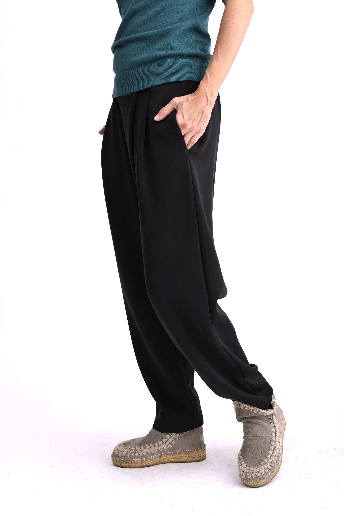 Pantaloni negri din material moale, cu talie elastică și croială conică, vedere laterală pe model.