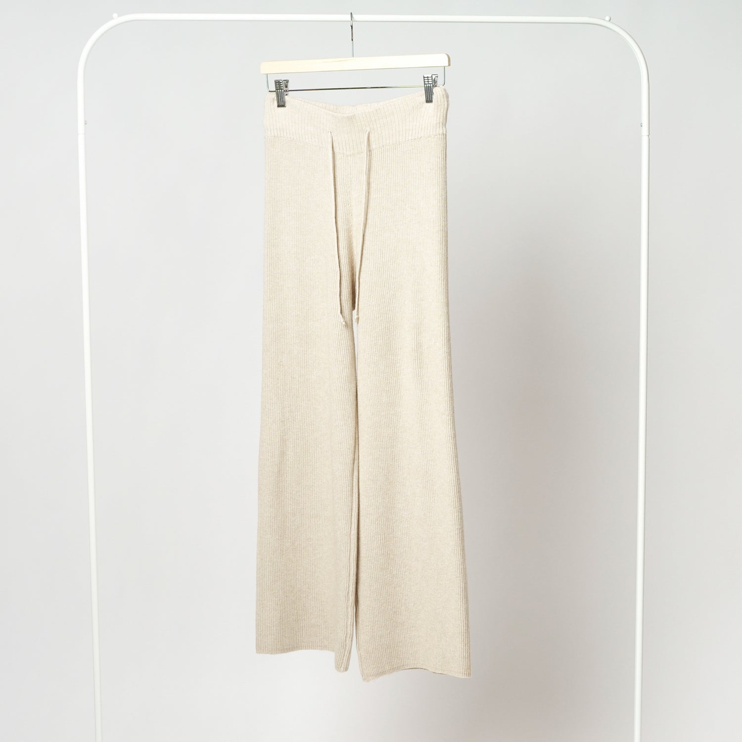 Pantaloni bej din tricot soft pe umeraș, croială lejeră, tiv drept, talie cu șiret.