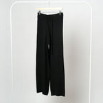 Pantaloni negri din tricot soft pe umeraș, talie elastică, textură moale și călduroasă.