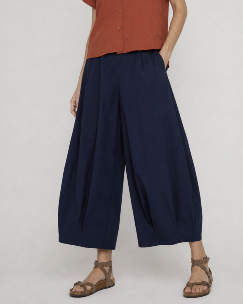 Pantaloni evazați bleumarin cu pliuri la tiv, vedere frontală. All Above Boutique.