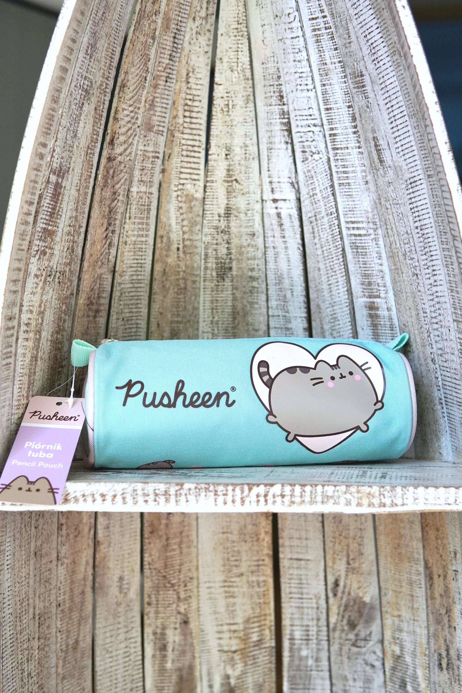 Penar tip tubă Pusheen, culoare verde mentă, imprimeu cu inimă, fermoar cu cursor, fotografiat pe raft din lemn.