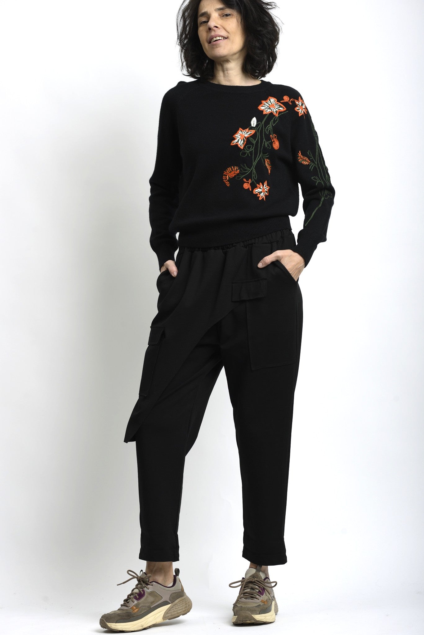 Vedere completă a puloverului cu broderie florală, purtat cu pantaloni lejeri, pentru o ținută casual.