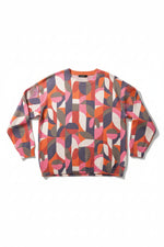 Pulover colorat cu model geometric abstract, prezentat flat lay pe fundal alb, cu nuanțe de roz, portocaliu și gri.