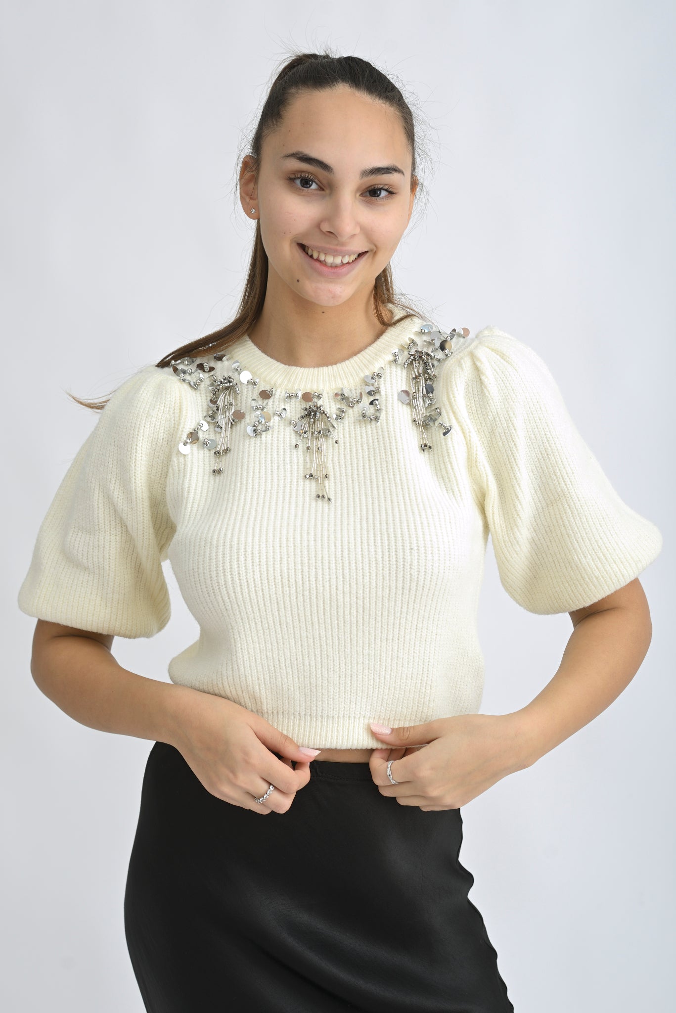 Pulover cu mânecă scurtă și aplicații decorative pe umeri, într-o nuanță delicată de crem.