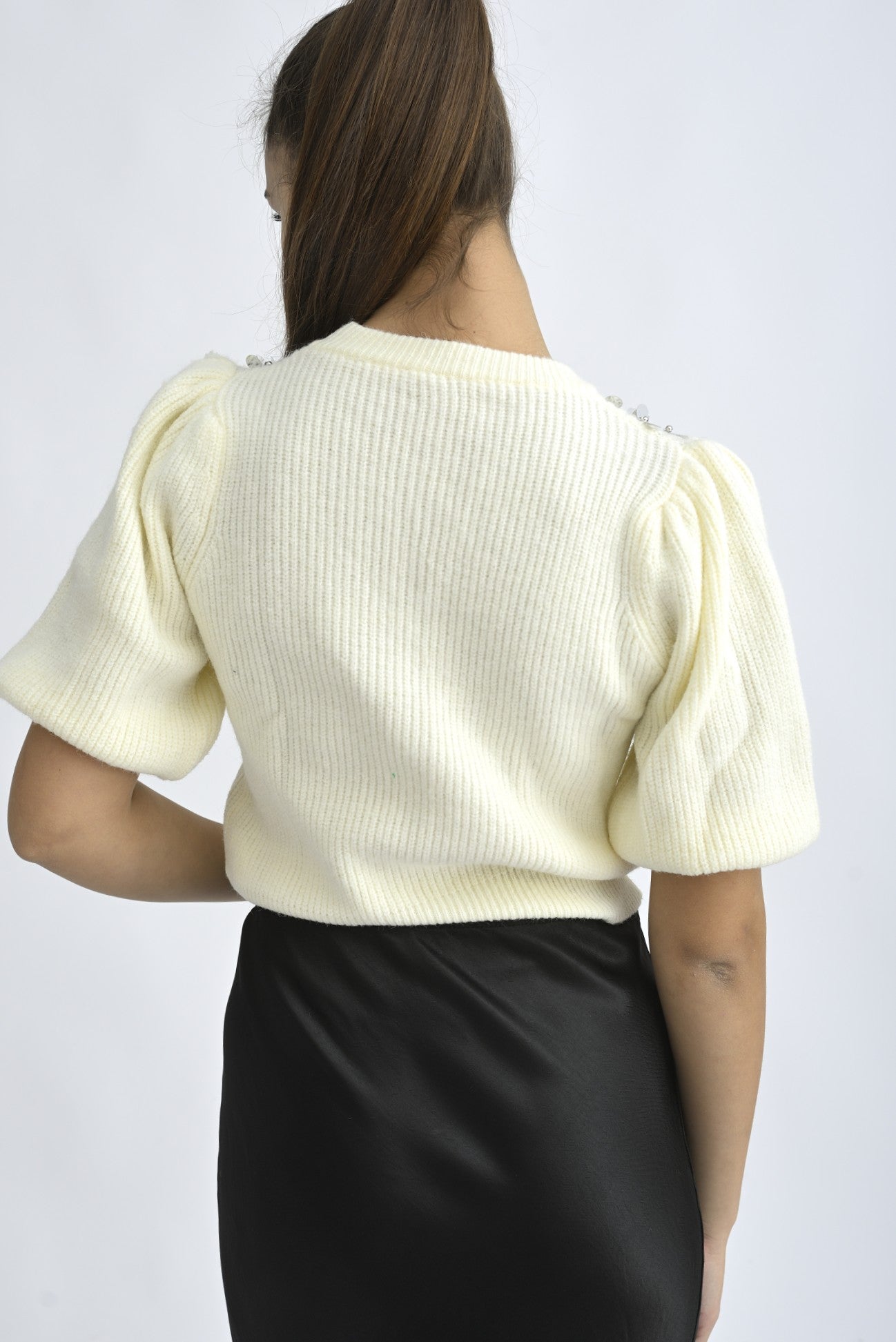 Pulover cu mânecă scurtă și aplicații decorative pe umeri, într-o nuanță delicată de crem.