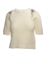 Pulover crem cu mânecă scurtă și aplicații elegante pe umeri, confecționat din material moale și elastic.