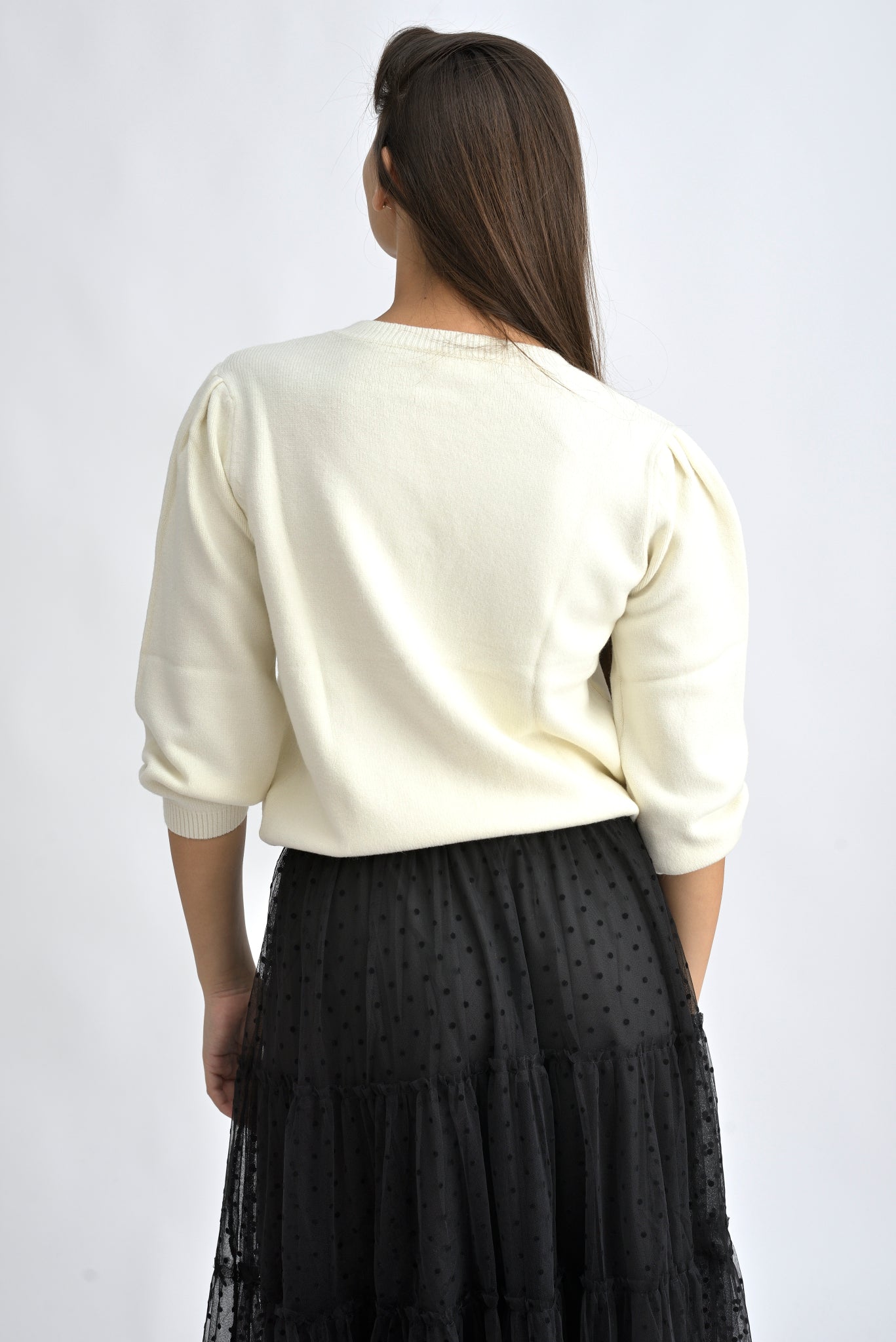 Pulover crem cu umeri bufanți și croială lejeră, realizat dintr-un amestec de viscoză și poliamidă.