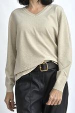 Pulover cu decolteu în V, din fir fin cu lurex discret, purtat într-o ținută casual elegantă.