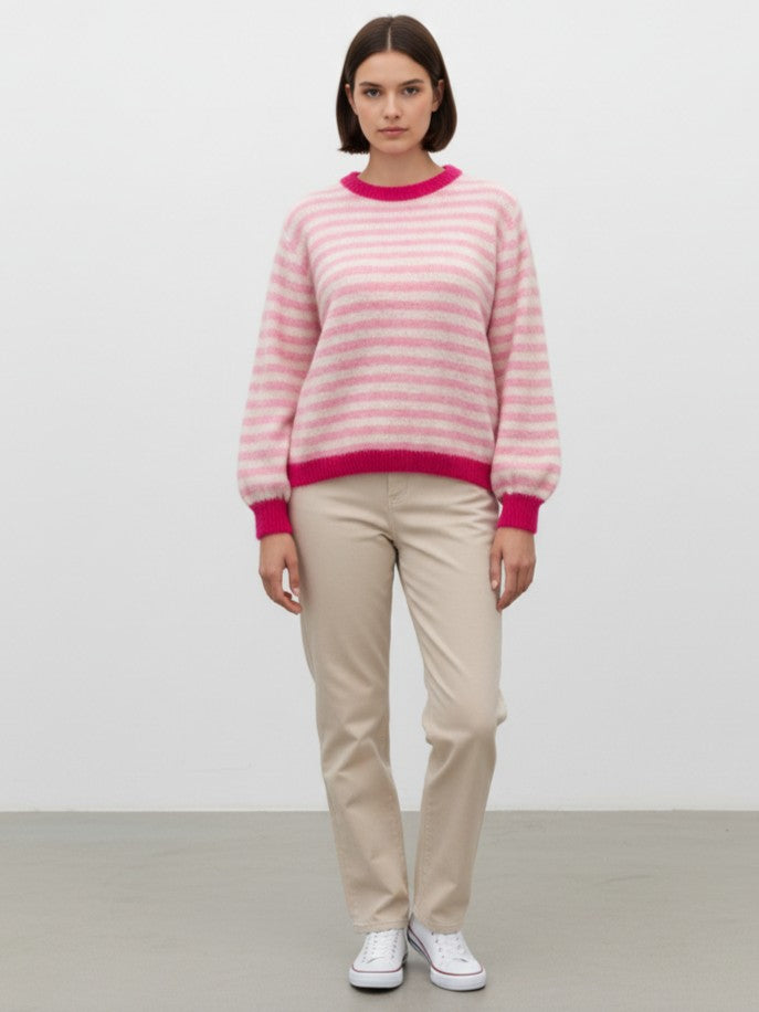 Pulover cu dungi colorate purtat într-o ținută relaxată, evidențiind lungimea și proporțiile.