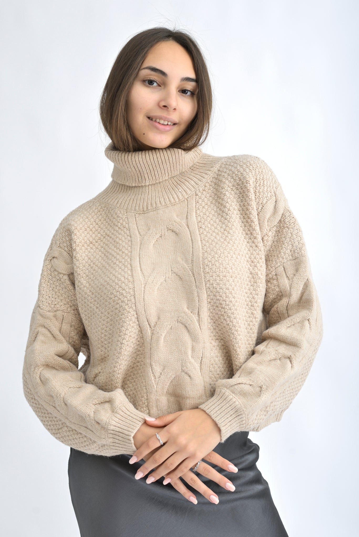 Pulover bej tricotat gros cu model bob de orez și torsade, vedere frontală pe model, croială lejeră și guler înalt.