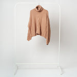 Detaliu de material tricotat cu torsade și model bob de orez, textură groasă, moale și călduroasă.