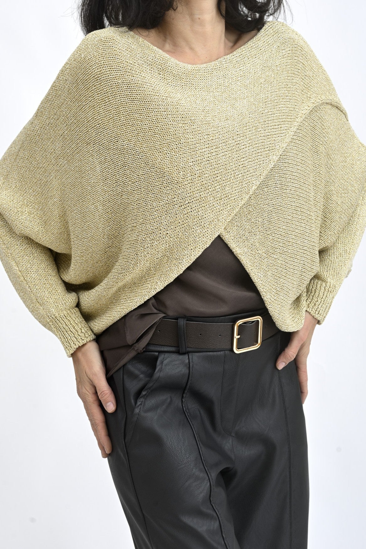 Pulover cu decolteu larg și umeri căzuți, purtat peste un top, într-o ținută urbană.