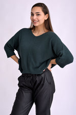 Detaliu de material al puloverului tricotat verde, textură densă tip bob de orez, realizat în Italia.