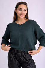 Pulover lejer tricotat verde, textură bob de orez, cu umeri căzuți și croială relaxată, prezentat pe model, vedere din față.