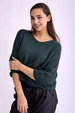 Pulover tricotat lejer verde, textură bob de orez, vedere din spate pe model, croială lungă la spate.