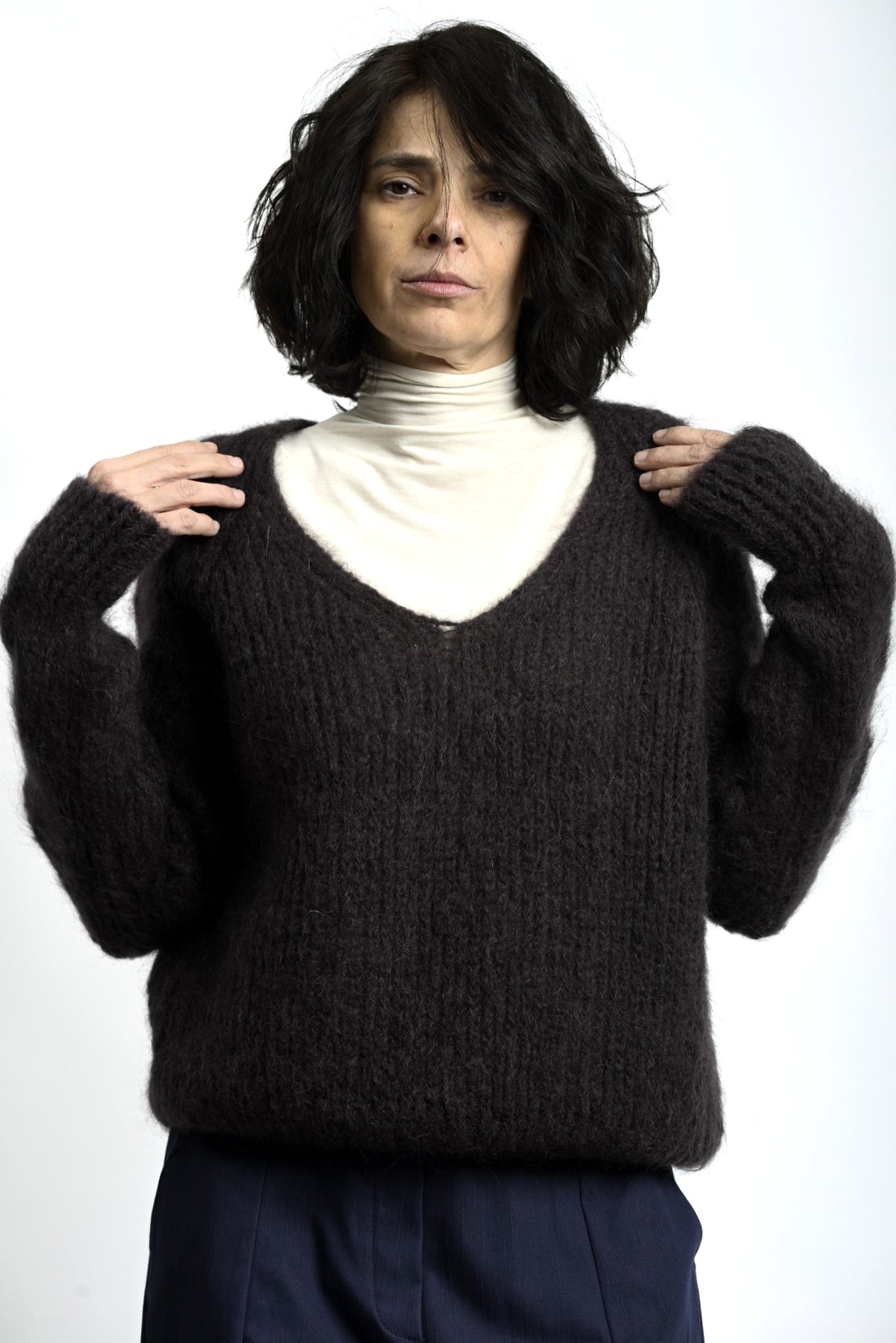 Detaliu de textură pufos-aerată a puloverului din mohair, cu tricotaj lejer și aspect natural.