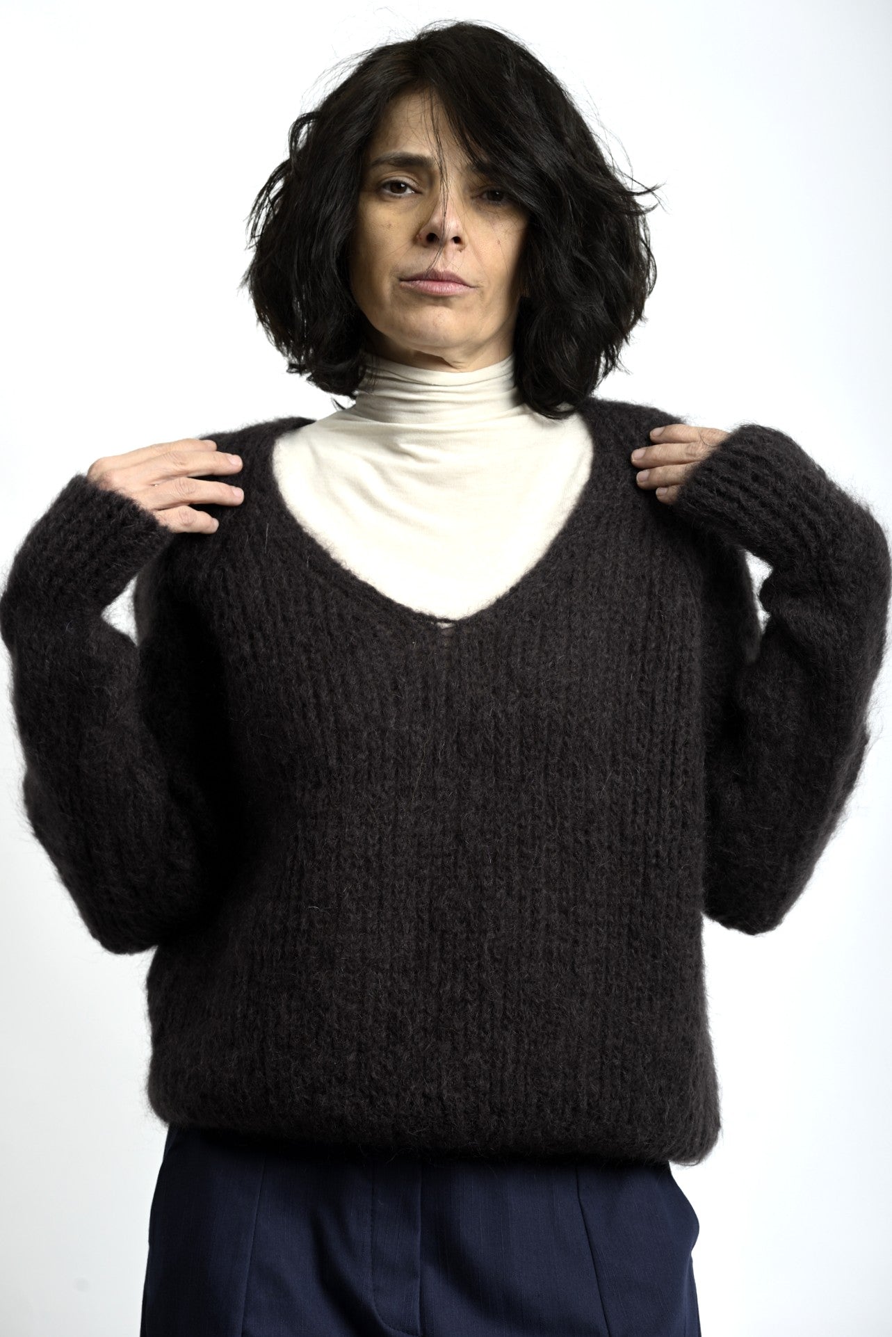 Detaliu de textură pufos-aerată a puloverului din mohair, cu tricotaj lejer și aspect natural.