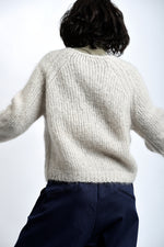 Pulover pufos din mohair, cu decolteu în V și croială lejeră, purtat peste helancă.