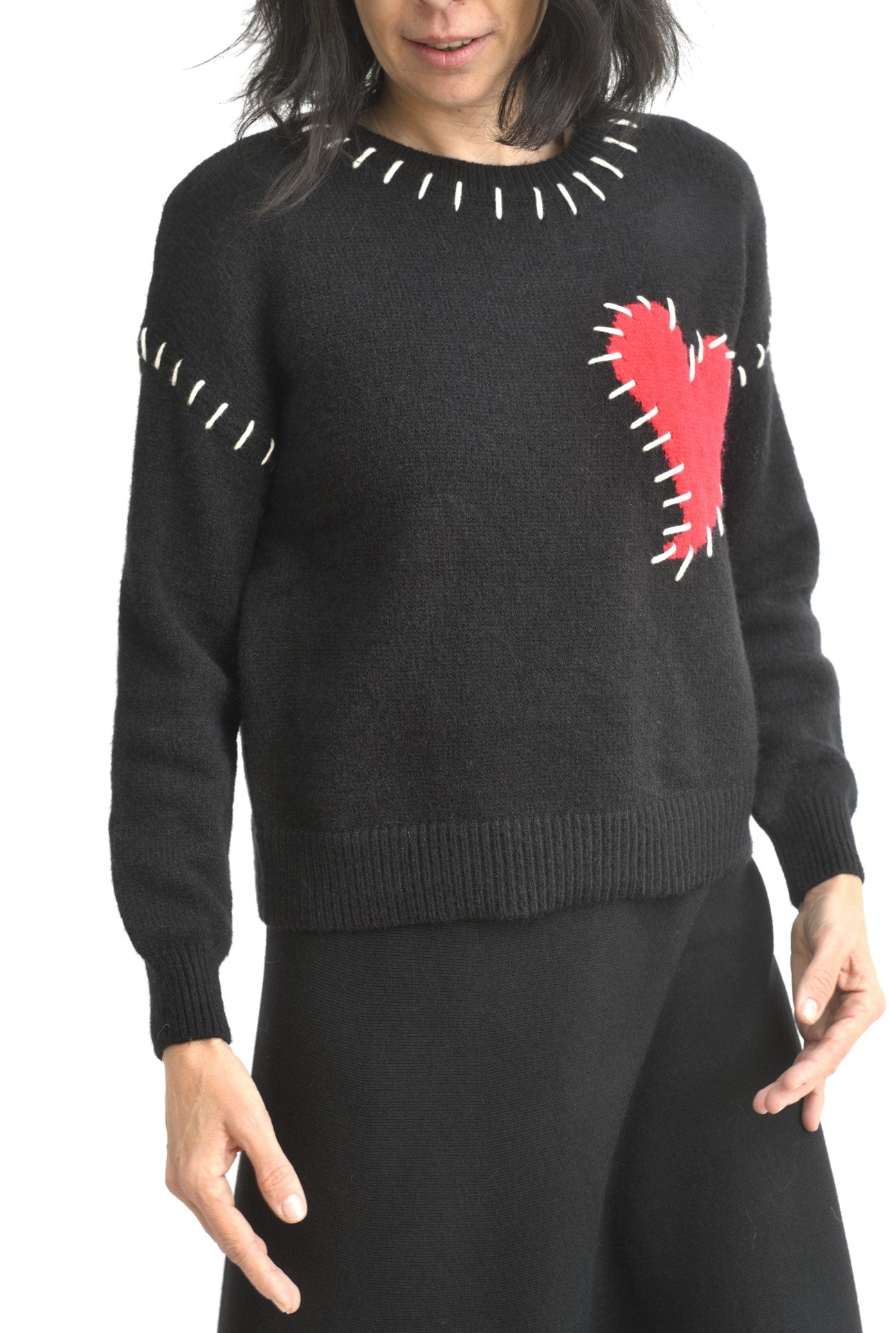 Detaliu de mânecă la puloverul negru, din tricot moale, cu finisaj elastic la manșetă.