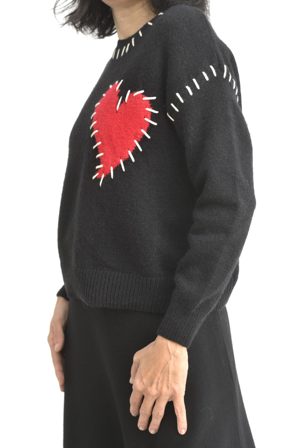 Pulover negru simplu văzut din spate, cu croială lejeră și umeri căzuți.