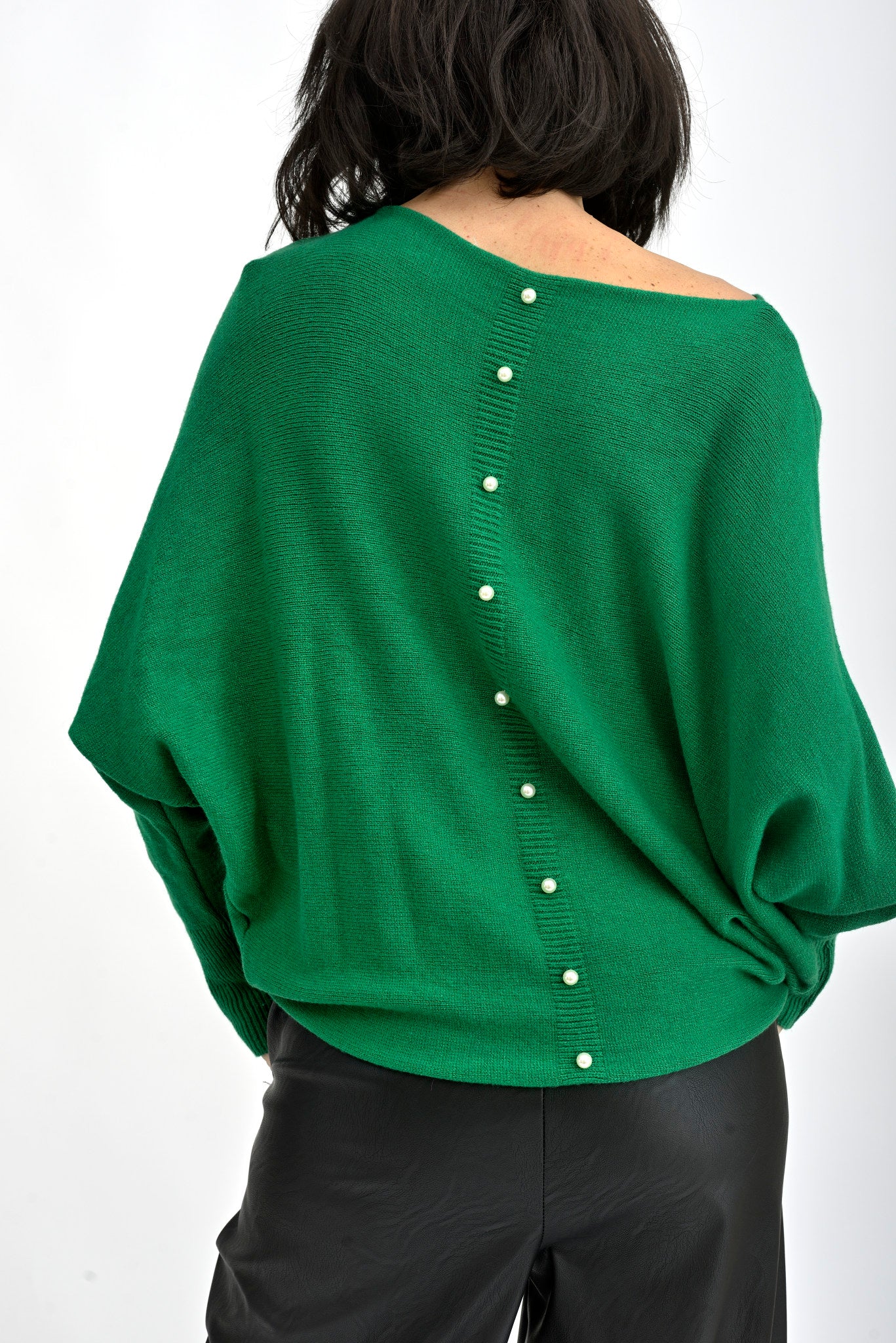 Detaliu spate pulover verde cu aplicații de perle decorative dispuse vertical, element elegant și feminin