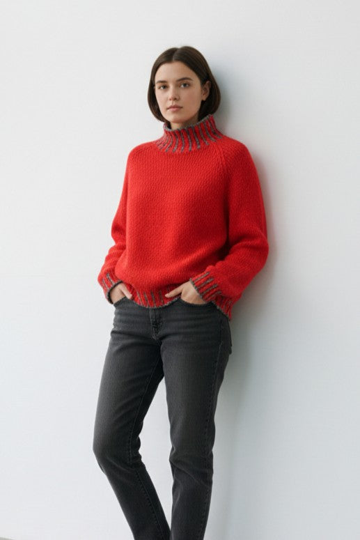 Pulover tricotat cu croială lejeră și umeri căzuți, purtat casual cu blugi.