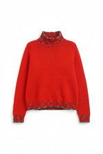 Detaliu tiv și manșete ale puloverului tricotat, cu inserții decorative în culoare contrast.