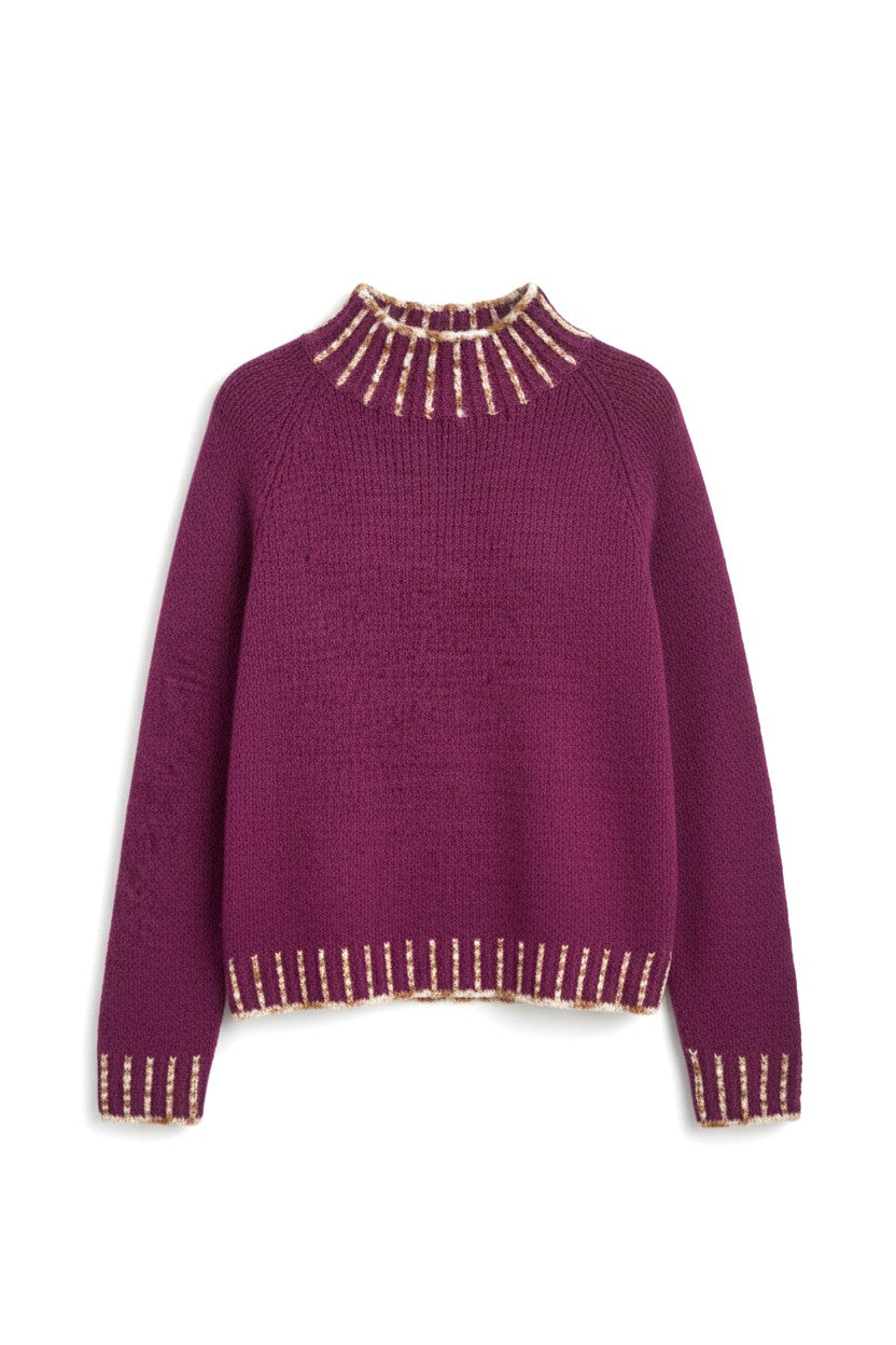 Detaliu tiv și manșete ale puloverului tricotat, cu inserții decorative în culoare contrast.