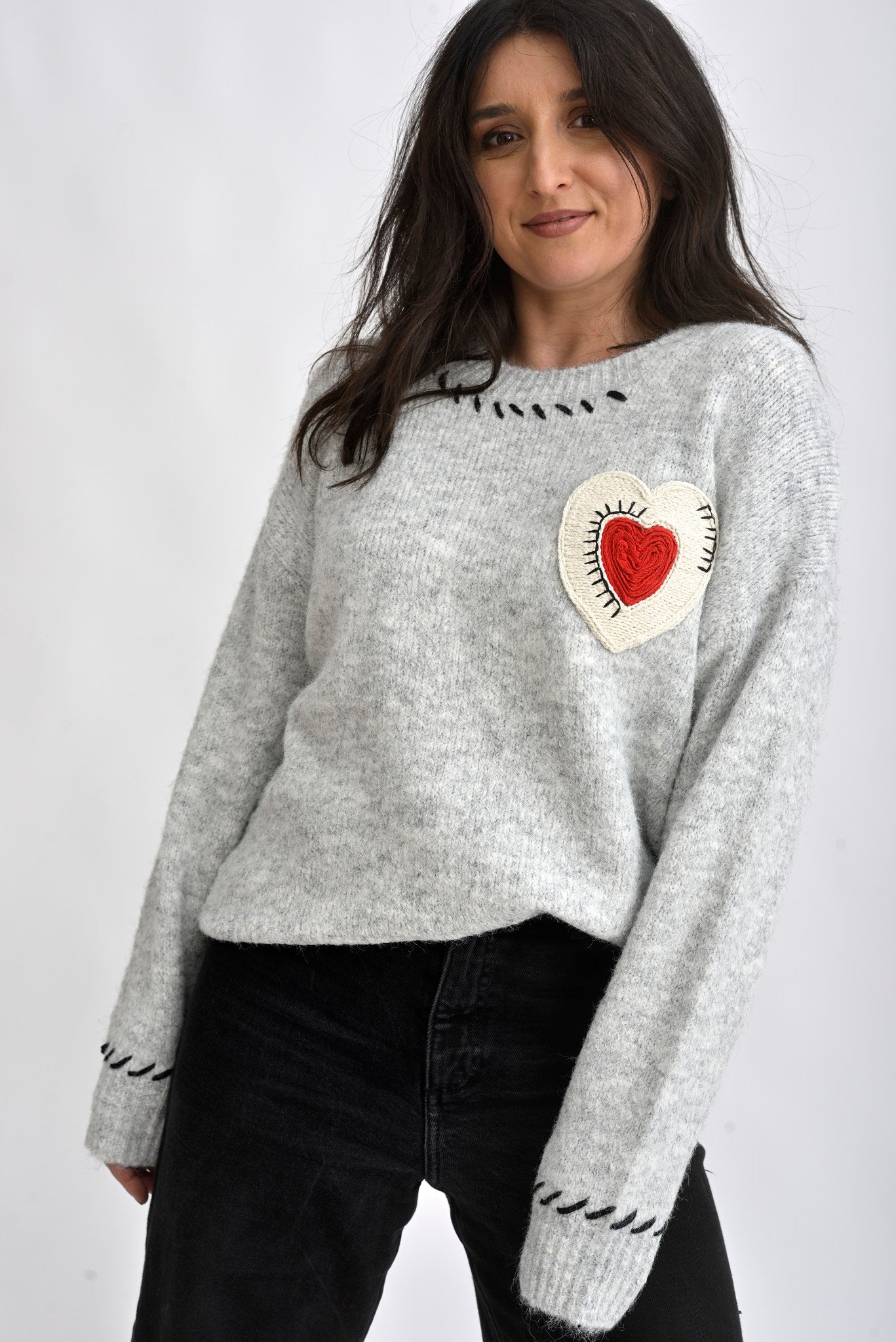 Pulover gri tricotat cu inima macramé aplicată pe piept, croială lejeră și umeri căzuți, vedere din față.