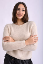 Model poartă pulover tricotat albastru intens, cu mânecă lungă și croială lejeră, pe fundal alb.